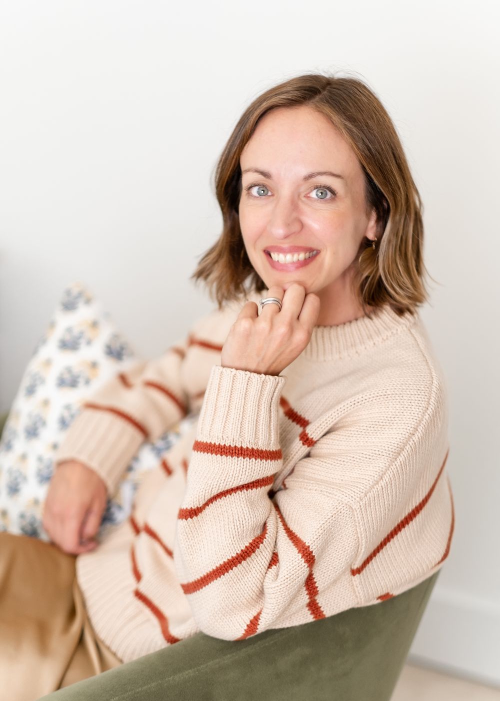 Amy Hyden smiling, seated in a striped sweater