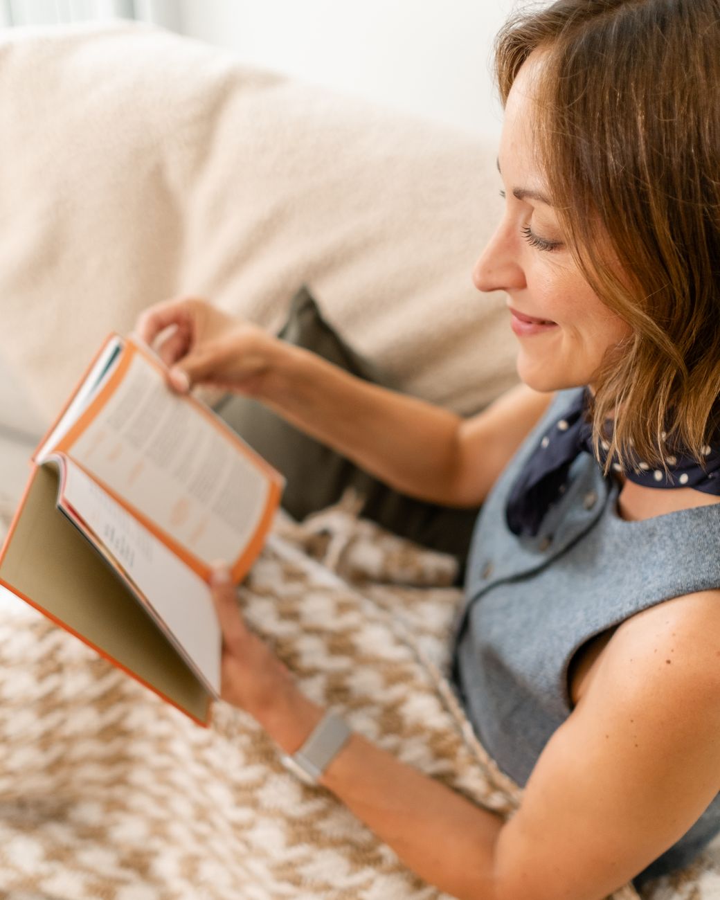 Amy reading a book under a houndstooth throw