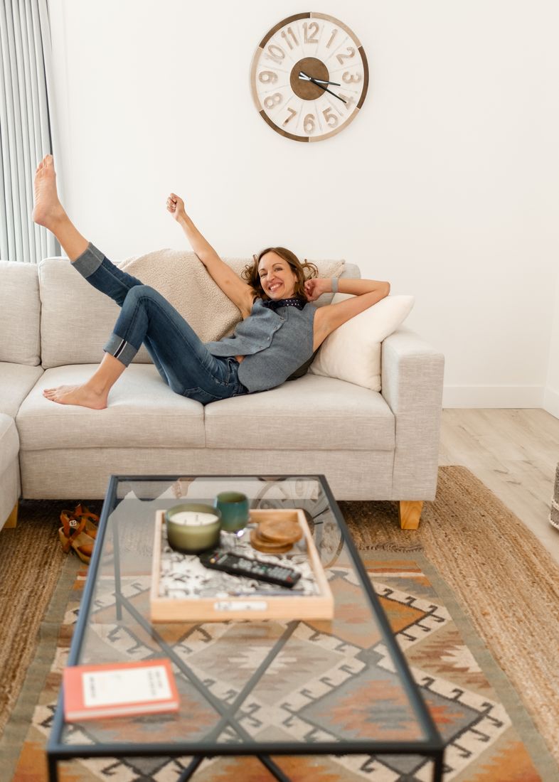 Amy laughing with her feet up on a sofa