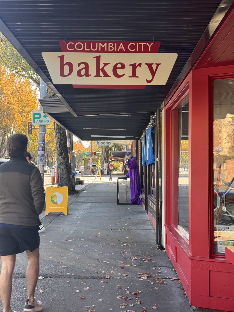 The red Columbia City Bakery sign under the awnings