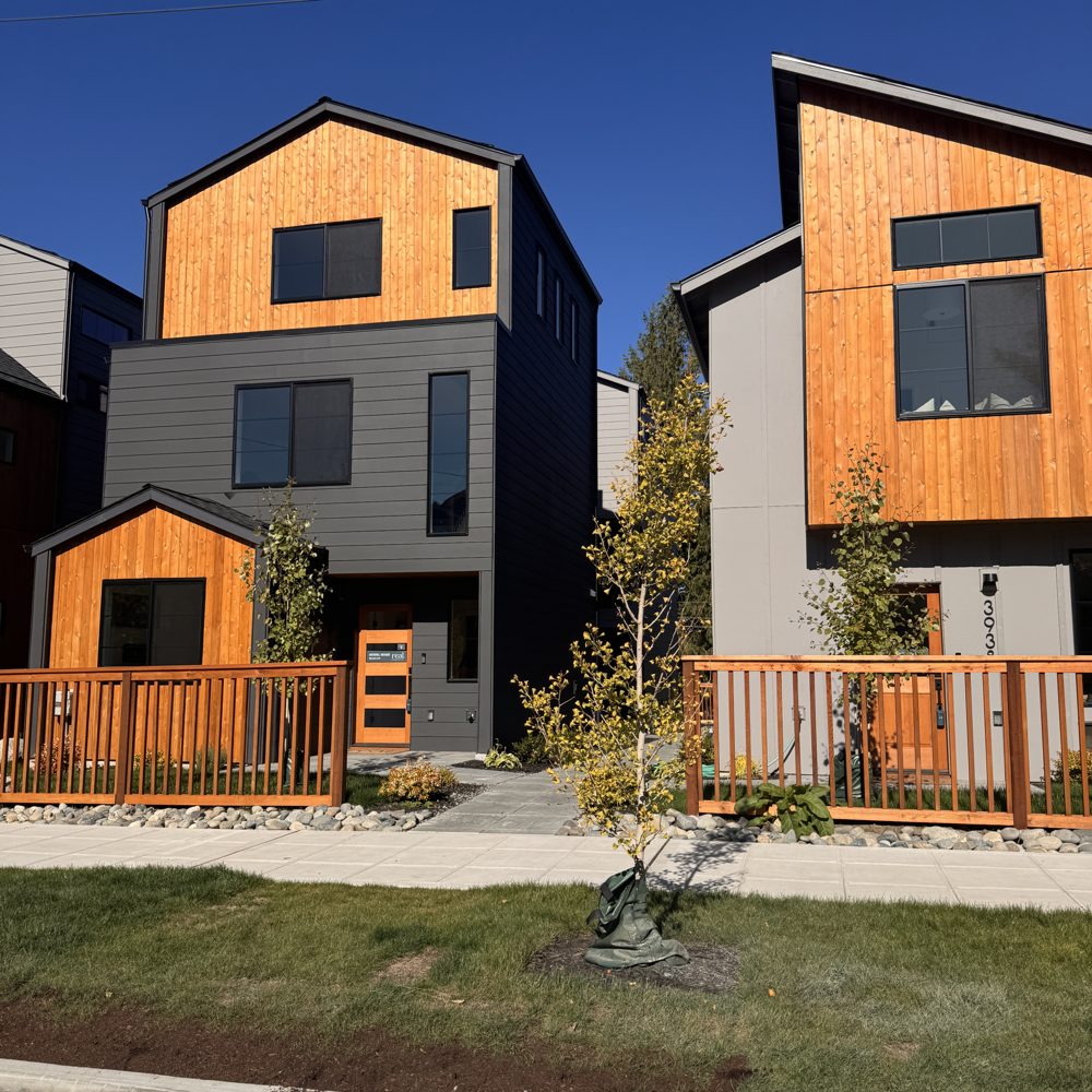 New townhomes with wood siding and small front porches