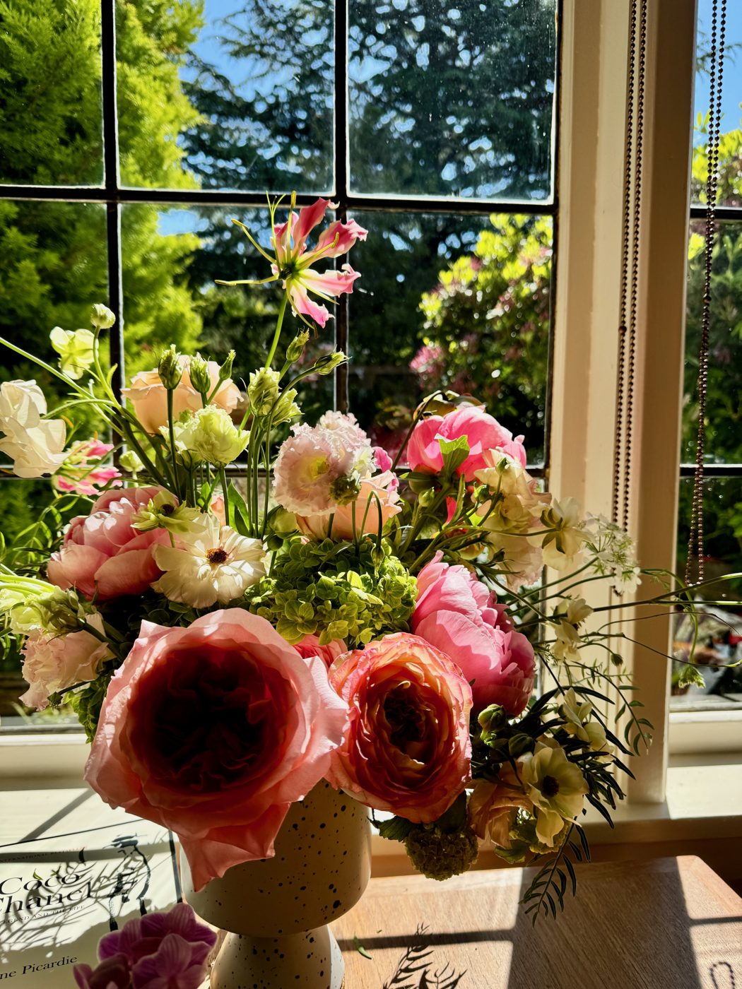 A bouquet of garden roses in a sunny window
