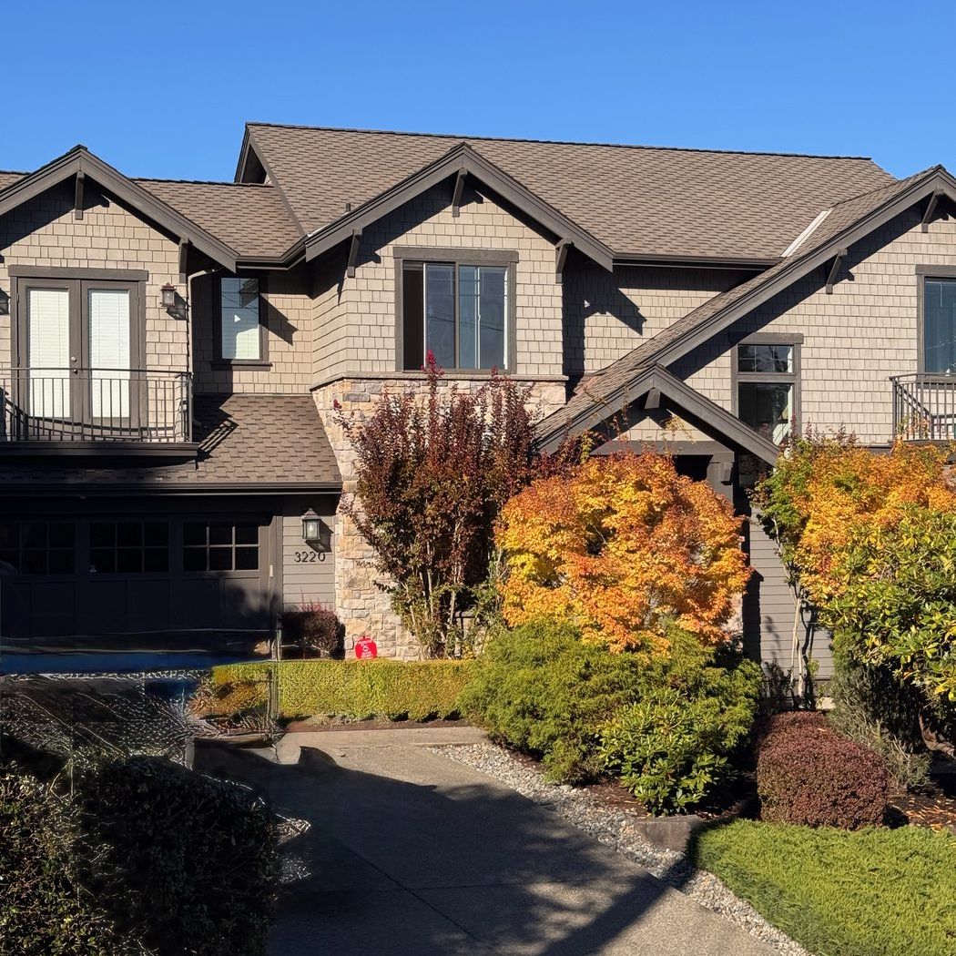 A two-story Craftsman-style home with fall shrubs out front
