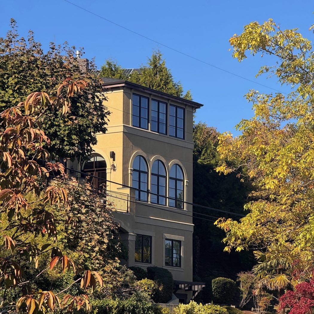 A tall Mediterranean-style home with arched windows set into the hillside