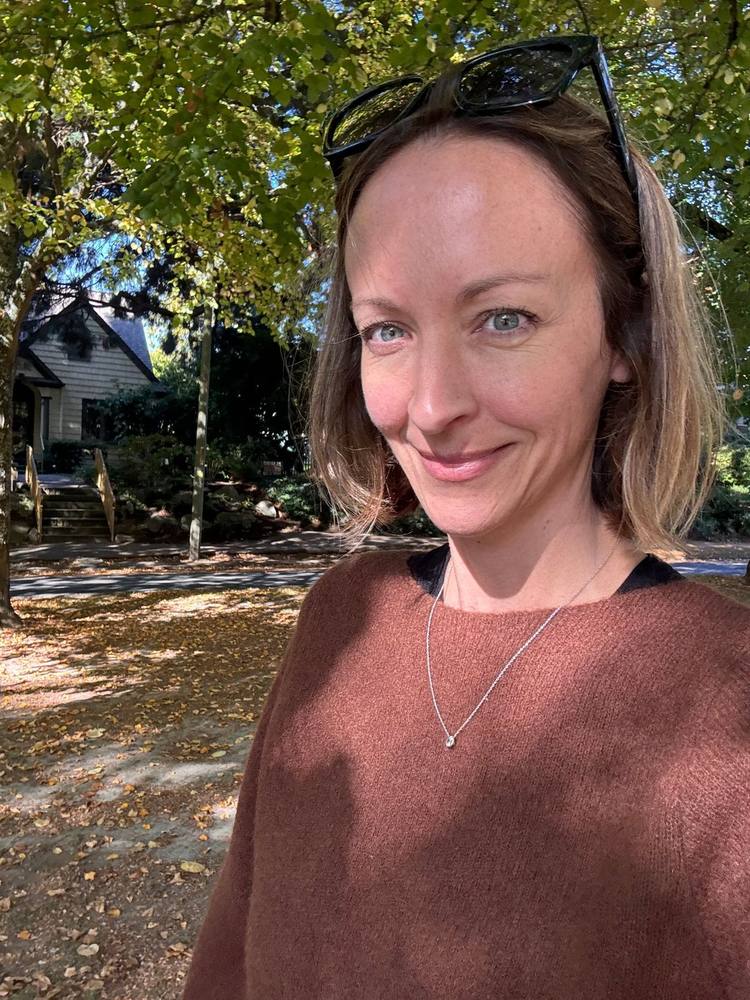 Amy Hyden smiling on a tree-lined street in Mount Baker