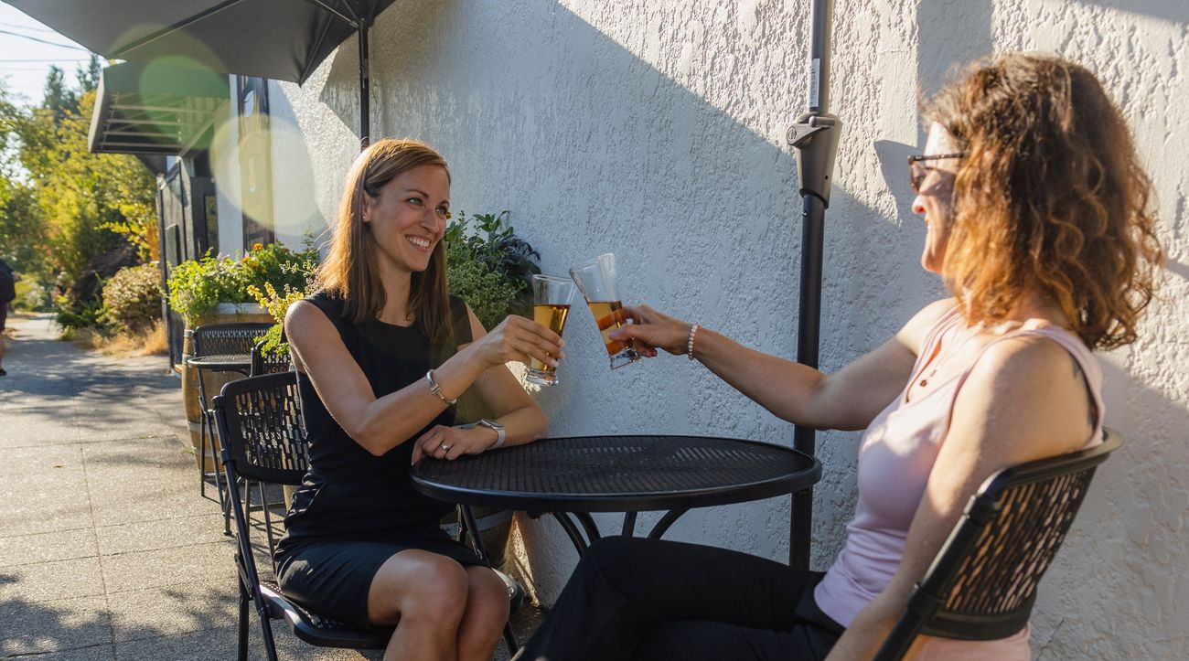 Amy and a client toasting at a sunny Seattle patio